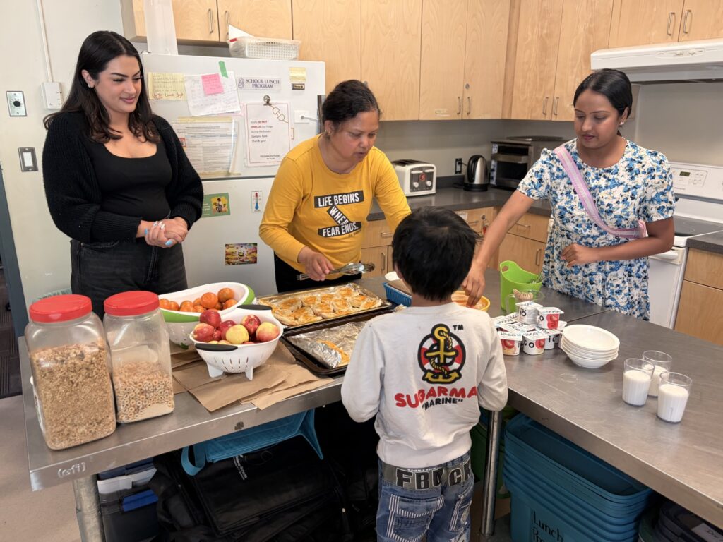 OpenRoad's Sim Varpaul (left) and Ashikaa Naidu (far right) helping school meal aide Deepa Syunry (centre) serve breakfast. For Adopt-a-School. Mandatory credit: Dallas Chou. For use with related story only Photo by Dallas Chou /Special to the Vancouver Sun